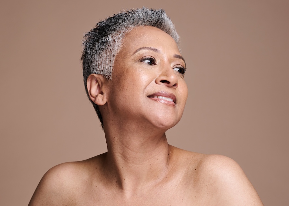 Woman smiles while experiencing the benefits of HRT for menopause in Leawood, which include better mood, sleep, hair and skin health, and cardiovascular health