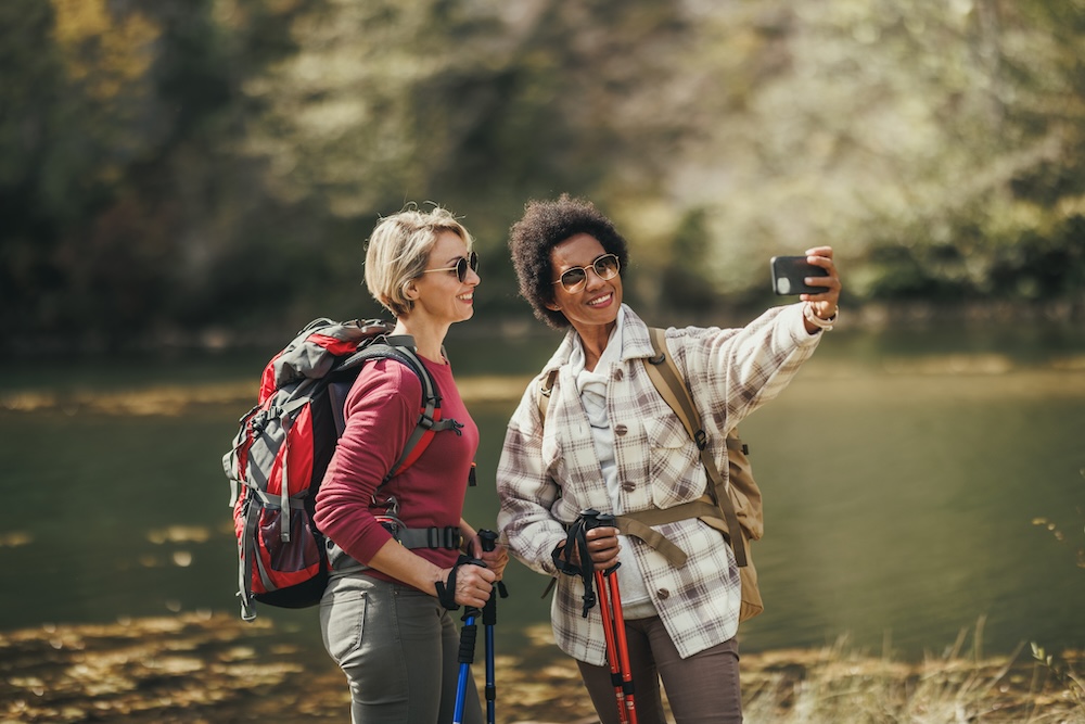 Two women taking a selfie on an outdoor hiking trail because they have renewed energy from bioidentical hormone replacement therapy in Leawood