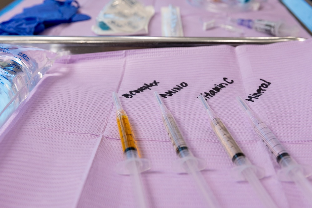 Four syringes are neatly laid out on a medical pad with labels listing their contents above them. They have been prepared for a vitamin drip in Kansas City to help boost the patient’s immunity and energy.