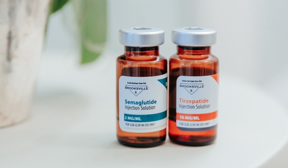 Bottles of semaglutide and tirzepatide placed neatly on a counter. These two weight loss injectables in Leawood help patients maintain a calorie deficit so they can slim down sucessfully.