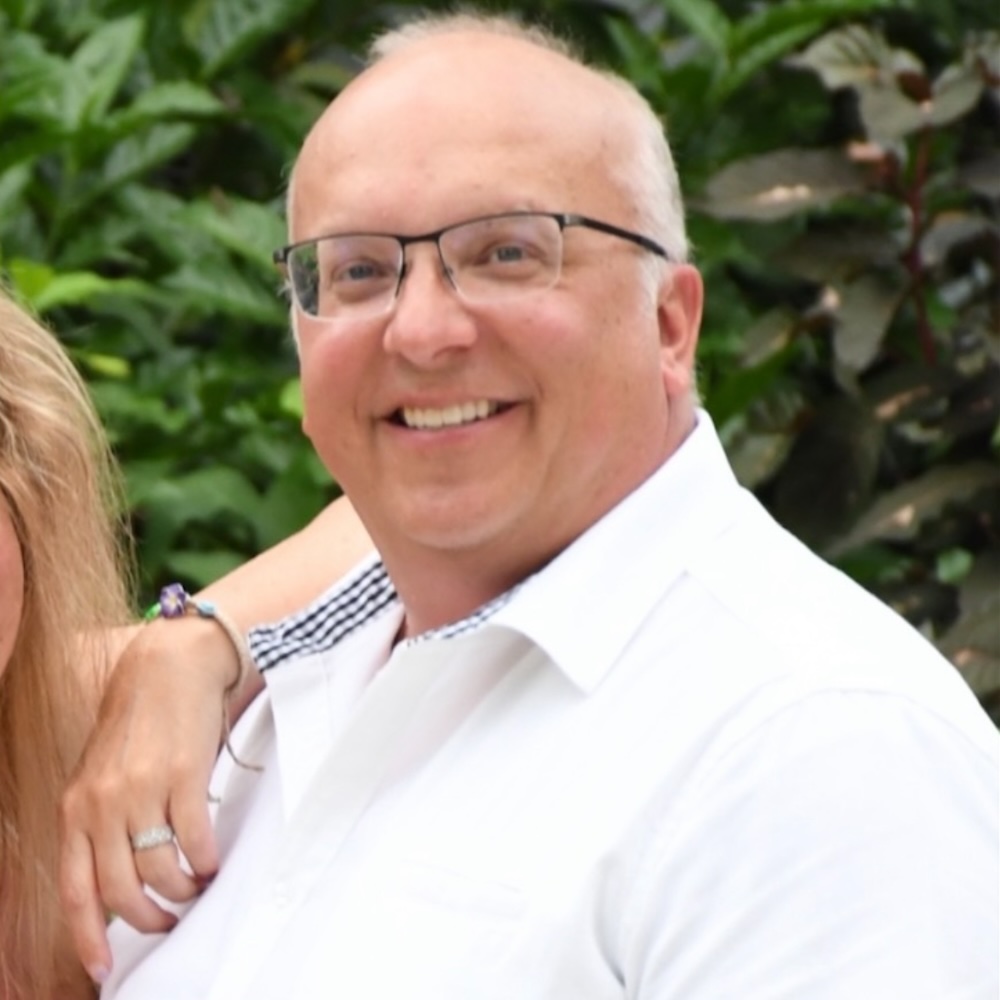 Image of a patient before he started weight loss injectables in Leawood. He wearing glasses and smiling at the camera.