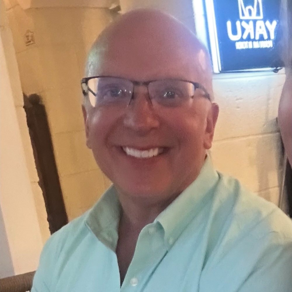 A photo of a patient after he lost weight with weight loss injectables. He is smiling and looks more confident than in his 'before' images.