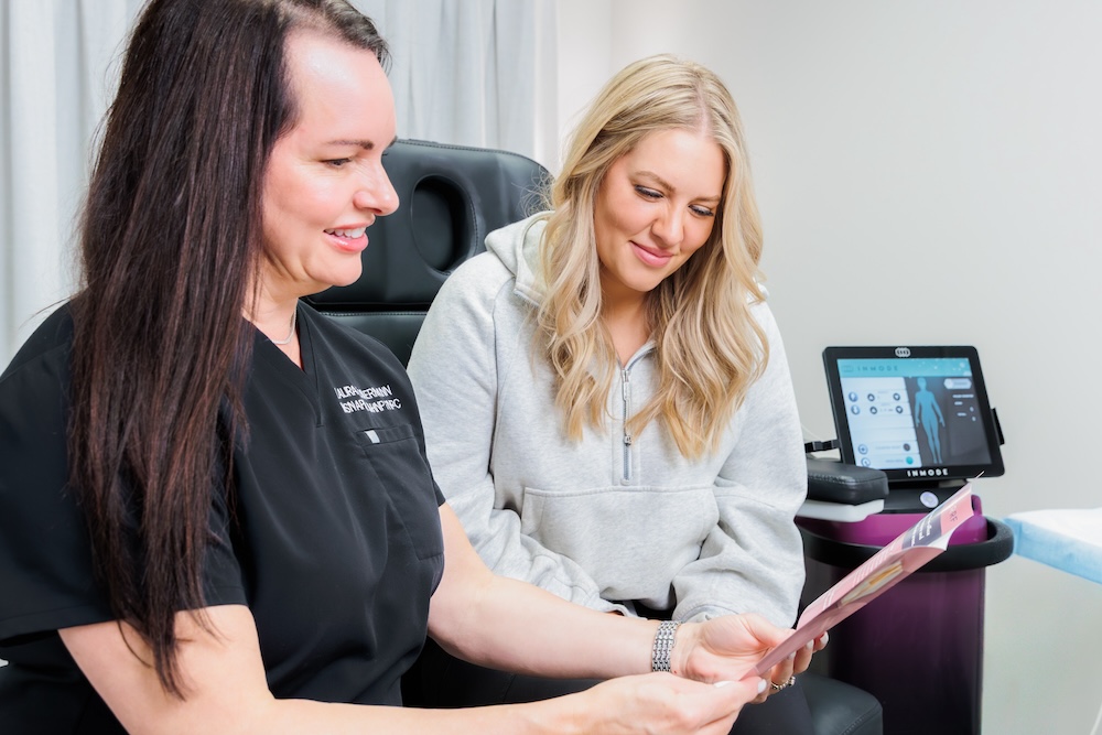 Provider and female patient reading an informational pamphlet explaining the treatment options for vaginal tightening in Leawood.