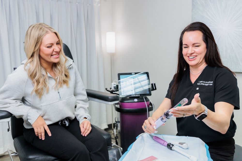 Provider and female patient holding the Empower by Inmode a urinary incontinence treatment in Leawood.